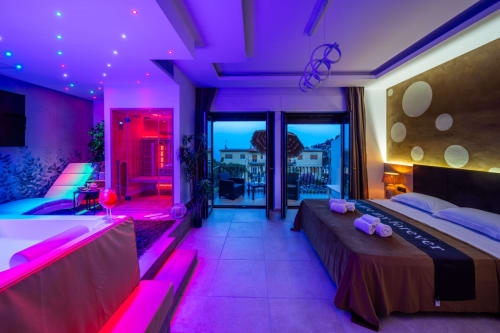 Modern Superior Suite at Taormina B&B with neon-lit bedroom, sea view balcony, and contemporary amenities