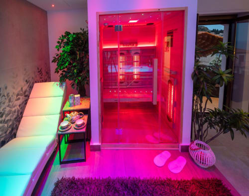 Modern apartment entrance with neon pink lighting, potted plants, and contemporary furnishings at Suite Apartment Taormina,