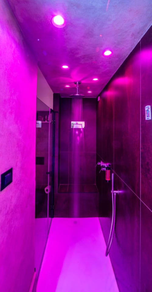 Modern shower room with vibrant magenta neon lighting at Suite Apartment Taormina luxury suite in Sicily