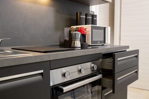 Modern kitchenette in Superior Suite apartment at Taormina hotel with stainless steel oven, coffee maker, and dark