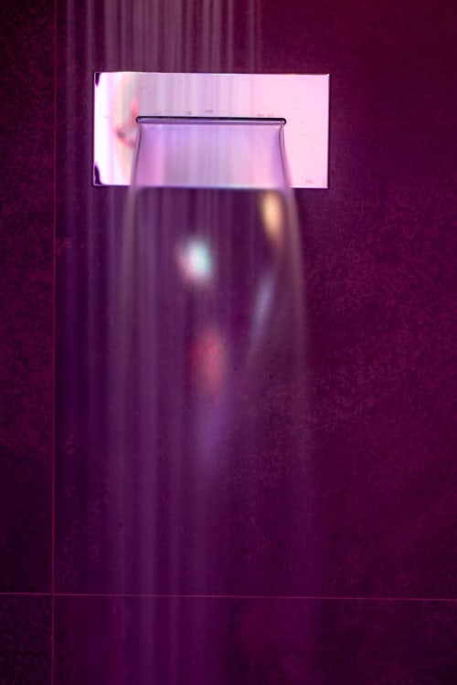 Empty glass on purple-lit wall at Suite Apartment Taormina, a sea-view suite apartment in Sicily