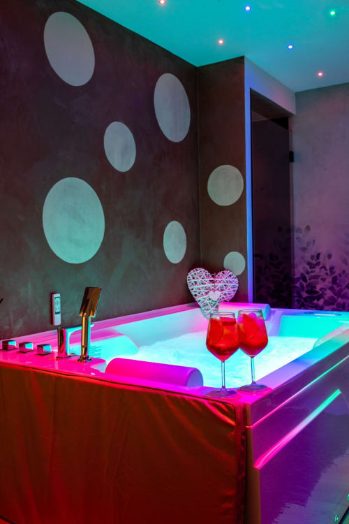 Modern neon-lit bathroom at Suite Apartment Taormina with illuminated basin, heart decoration, and colorful ambient lighting