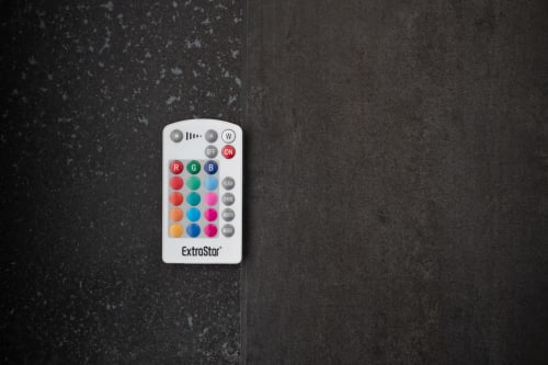 ExtraStor remote control with RGB color buttons on dark surface at Suite Apartment Taormina