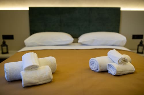 Rolled towels and bathrobes arranged on bed at Suite Apartment Taormina, a superior matrimonial room in Taormina, Sicily