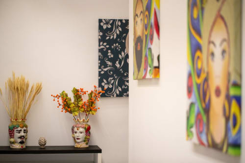 Decorative wall art and colorful Moor head vases with flowers in Taormina suite apartment room
