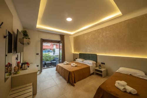 Luxury suite bedroom at Suite Apartment Taormina with twin beds, modern lighting, balcony view, and marble flooring