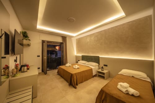 Luxurious bedroom suite at Taormina B&B with twin beds, ambient ceiling lighting, balcony view, modern amenities