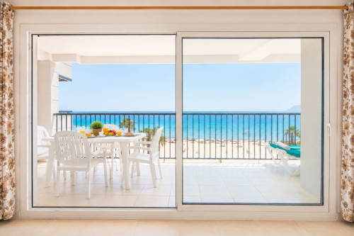 Balcón frente al mar en apartamento Riurau Home Calpe con mesa de comedor con vistas al turqueso Mar Mediterráneo y playa de arena