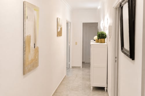 Modern hallway at Cannes Location - Pascale Beaud hotel with white walls, tile flooring, and minimalist decor