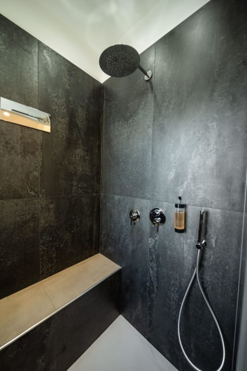 Modern dark tile shower with rainfall showerhead and handheld spray at Suite Apartment Taormina, Sicilian luxury