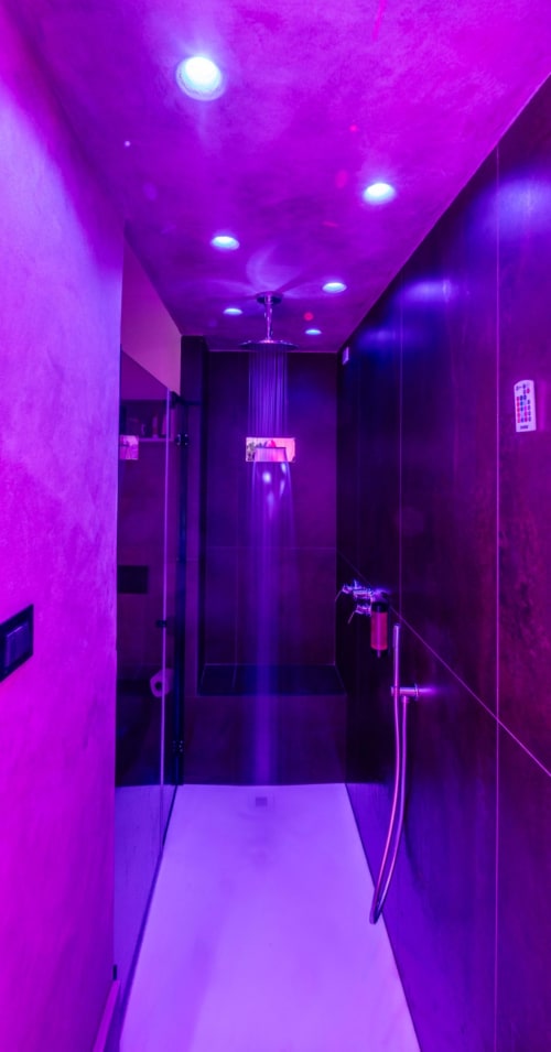 Modern bathroom with vibrant purple neon lighting and ceiling fixtures at Suite Apartment Taormina, Taormina Sicily