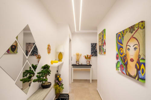 Modern hallway in Taormina suite with pop art decor, bonsai plants, and colorful wall art