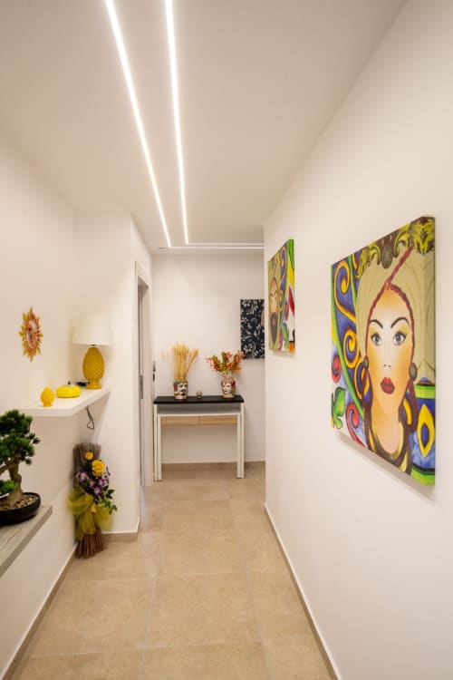 Modern hallway in Taormina suite with colorful pop art, yellow decor, and contemporary lighting