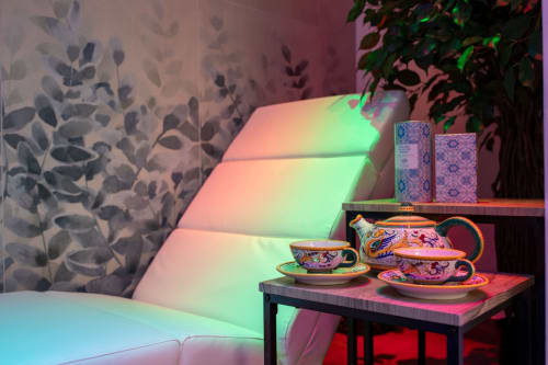 Colorful ceramic tea set displayed in Suite Apartment Taormina, with illuminated seating and botanical wall art, Taormina,