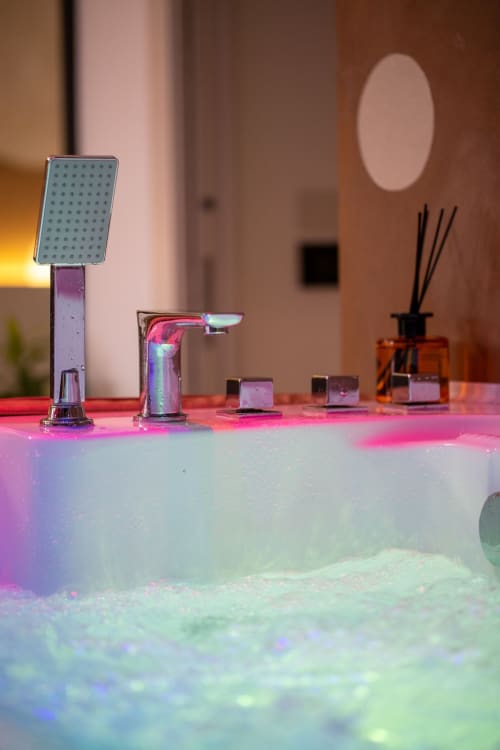 Luxury bathroom fixtures with modern chrome design at Suite Apartment Taormina, featuring ambient lighting and elegant