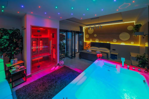 Luxurious suite apartment in Taormina with neon-lit indoor pool, sauna, and modern spa amenities