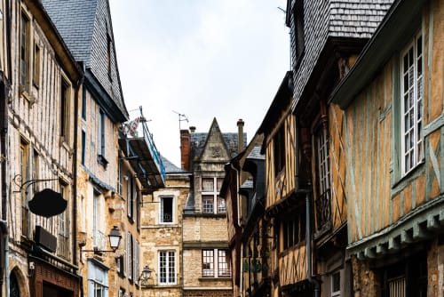 Medieval stone buildings lining narrow street in Le Mans, France near L'escapade hotel