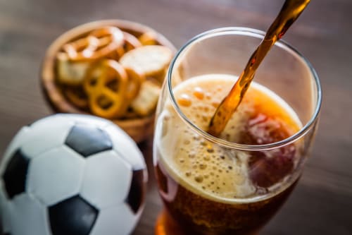 Un verre de cola versé avec un ballon de football et des collations à l'hôtel Ô de Mer à Sangatte