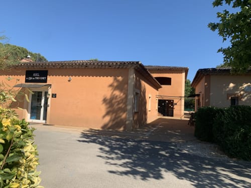 Entrée de l'hôtel Le Clos du Thoronet au Thoronet, France avec bâtiments en terre cuite et ciel bleu clair