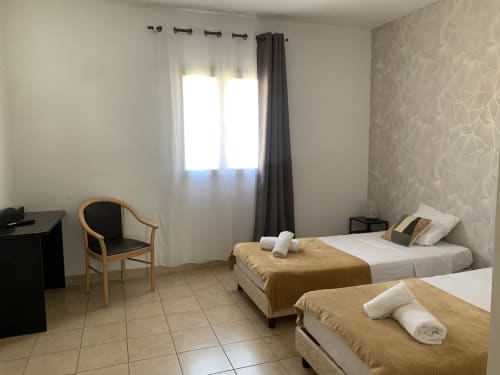 Chambre twin de l'hôtel Le Clos du Thoronet au Thoronet, France avec deux lits, bureau et fenêtre
