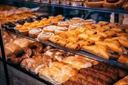 Bakery display case at Ô de Mer hotel in Sangatte featuring fresh pastries, croissants, and baked goods