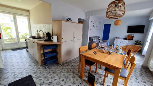 Open-plan kitchen and dining area at Ô de Mer in Sangatte with wooden table, modern appliances, and coastal decor