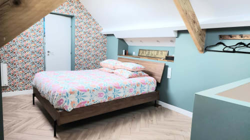 Chambre mansardée moderne de la villa Ô de Mer avec literie fleurie, murs turquoise et poutres apparentes à Sangatte