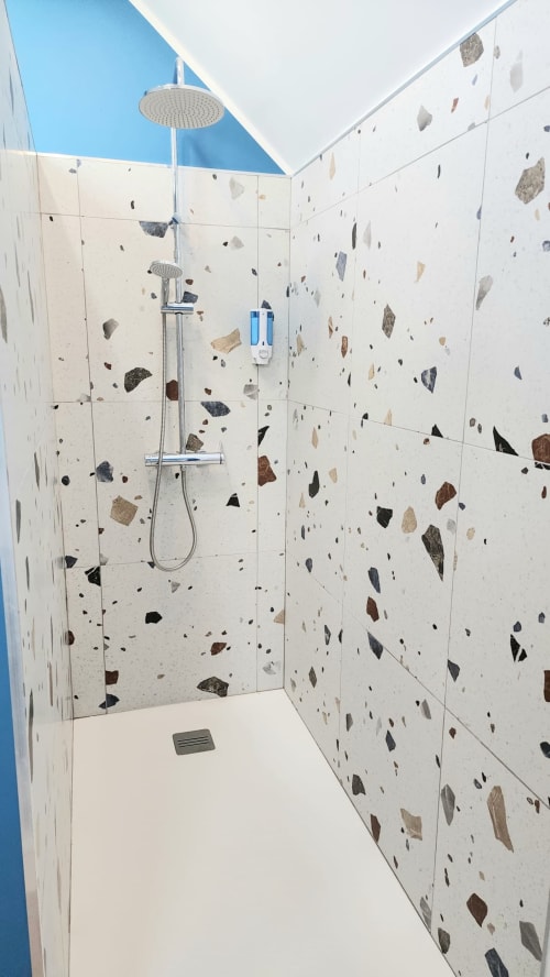 Douche moderne avec carreaux en terrazzo et pomme de douche effet pluie à la villa Ô de Mer à Sangatte