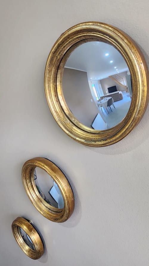 Miroirs ovales à cadre doré reflétant l'intérieur de la villa Ô de Mer à Sangatte avec mobilier contemporain visible