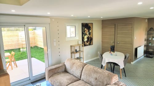 Salon moderne de la villa Ô de Mer avec vue sur le jardin, sièges confortables et portes-fenêtres donnant sur la pelouse