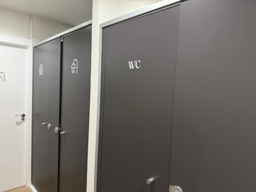 Shared bathroom entrance at Groma Rooms hostel in Zaragoza with WC and toilet door signs