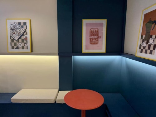 Groma Rooms hostel in Zaragoza: cozy lounge area with blue booth seating, red side table, and framed artwork on walls.