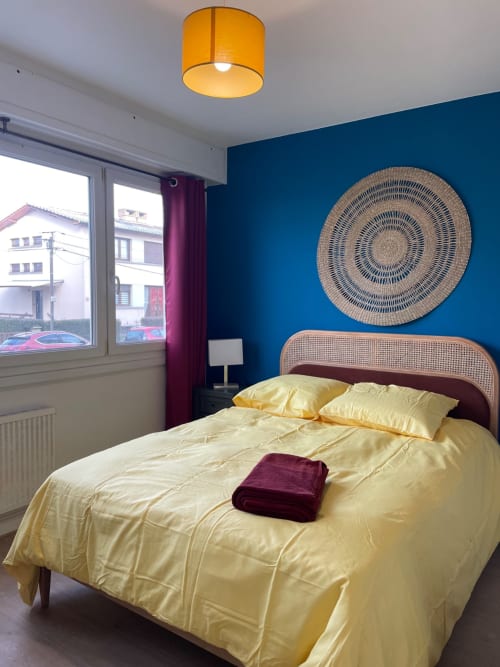 Chambre bleu vif avec literie jaune, art mural tissé et vue sur la ville chez Mattbnb à Metz, France