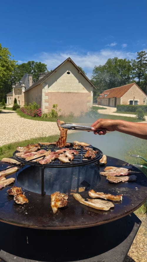 Grillade de viande à la Cloffy B&B à Nouans-les-Fontaines avec vue sur la rivière et bâtiments de domaine français