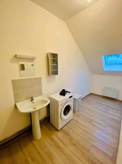 Buanderie avec lavabo, machine à laver et sèche-linge dans l'appartement Business Apparts Caudry