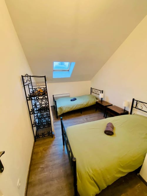 Chambre dans Business Apparts Caudry avec deux lits, puits de lumière et parquet