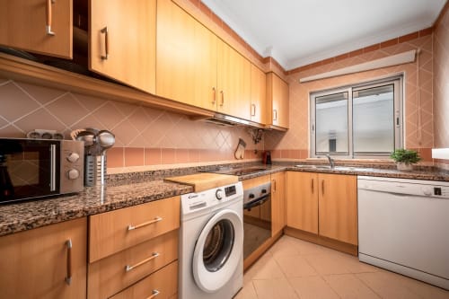 Cozinha moderna no apartamento The Quiet Nest em Atlantic Places Albufeira com armários em madeira e bancadas em granito