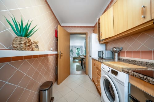 Cozinha moderna no apartamento The Quiet Nest em Atlantic Places, Albufeira, com azulejos de barro, armários de madeira e