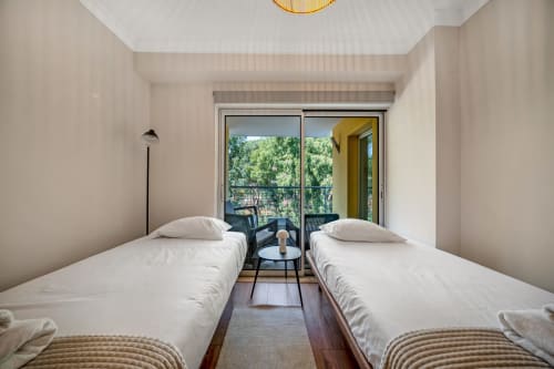 Quarto com duas camas e vista para o jardim no Atlantic Places, Albufeira - apartamento moderno e tranquilo com acesso a varanda
