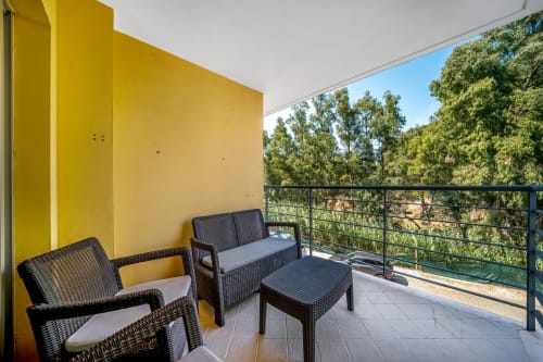 Varanda moderna do apartamento Atlantic Places em Albufeira com área de estar ao ar livre com vista para jardim paisagístico verdejante