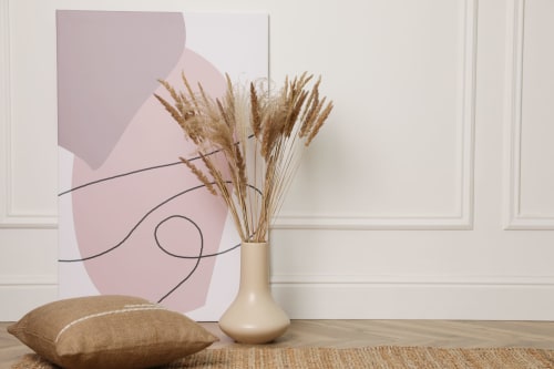Décor élégant de l'Hôtel le Tilleul avec herbes de pampa, vase beige et œuvre abstraite rose à Corps, France