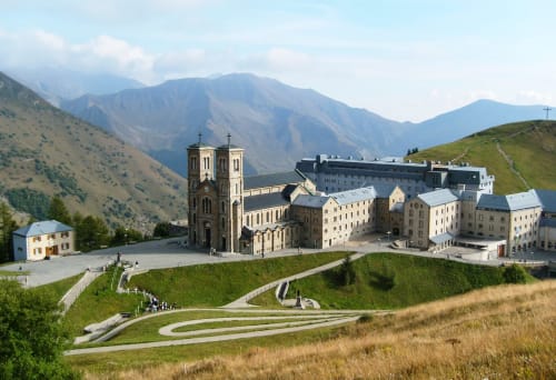 Monastère bénédictin niché dans les Alpes près de Corps, France, avec deux clochers et bâtiments en pierre sur fond de verdure