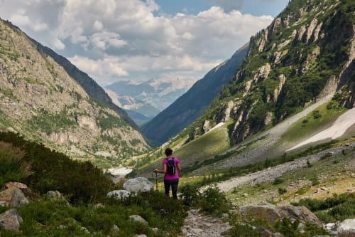 Randonneur au sac à dos violet sur le sentier de montagne dans la vallée de Corps, France, entre hautes falaises