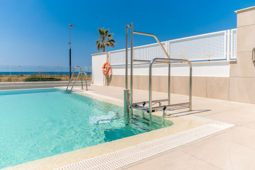 Piscina accesible frente al mar en Alhaurín Loft con vistas al mar, barandillas metálicas y paisaje mediterráneo
