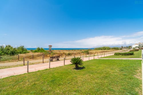 Parque frente al mar en Alhaurín de la Torre con césped cuidado, senderos de madera y vistas al Mediterráneo bajo cielo despejado