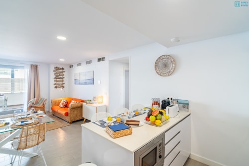 Cocina moderna luminosa y área de estar en Apartamento de Lujo Beachfront Maruchis con vistas al mar, abastecida con frutas frescas