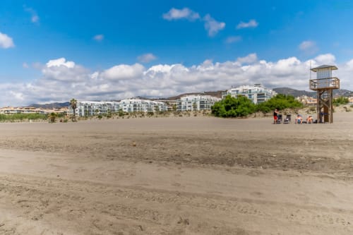 Complejo de apartamentos de lujo frente al mar en Alhaurín de la Torre con playa arenosa, torre de vigilancia y vistas a la montaña