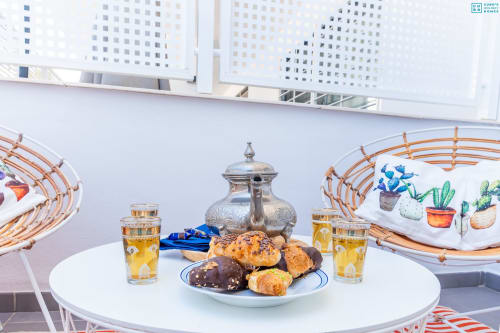 Elegante terraza en Alhaurín Loft con pasteles, bebidas y vistas de la ciudad de fondo
