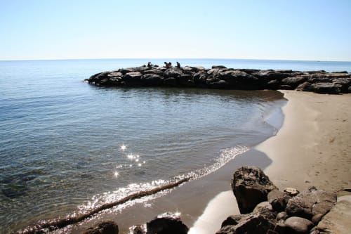 Spiaggia sabbiosa con onde delicate e affioramenti rocciosi a La Terrazza sul Ricetto a Marina di Andora, Italia