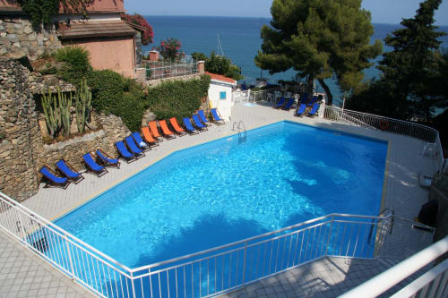 Piscina scintillante con lettini blu affacciati sul Mar Mediterraneo a La terrazza sul ricetto, Marina di Andora